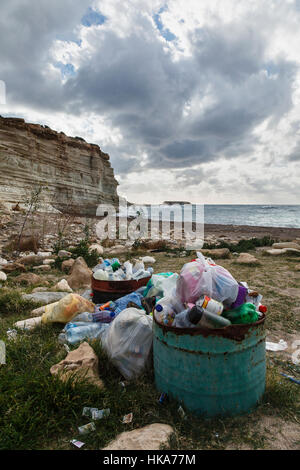 I rifiuti sulla spiaggia e la vista da Capo Drepano e Geronisos Island, vicino a Pegeia, Cipro Foto Stock