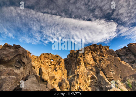 Cirrocumulus e cirrus nuvole sopra il foro-in-Wall rocce di Mojave National Preserve, CALIFORNIA, STATI UNITI D'AMERICA Foto Stock