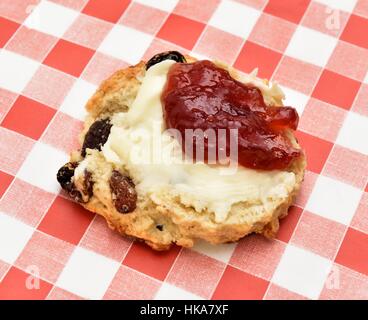 Un frutto scone con confettura di fragole e burro Foto Stock