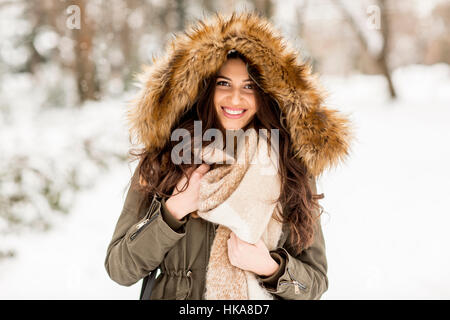 Giovane donna con una cappa di pelliccia nel parco sulla neve Foto Stock