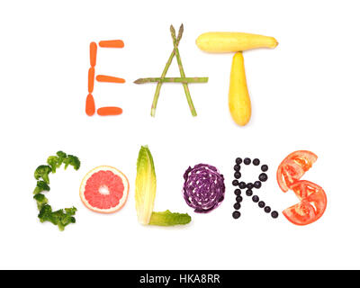 Mangiare i colori - testo enunciato in colorate alimenti vegetali; concetto di mangiare sano, su bianco Foto Stock
