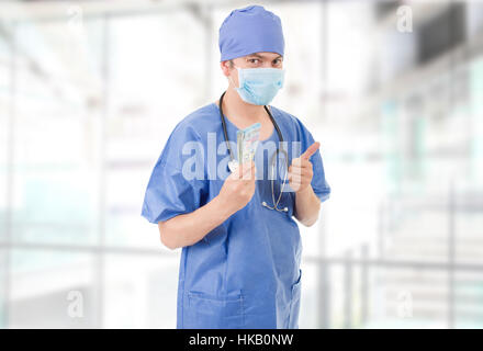Felice medico maschio holding di banconote presso l'ospedale Foto Stock