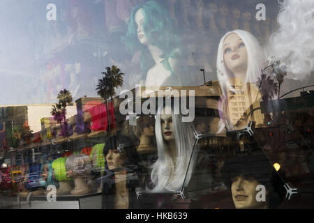 Los Angeles, CA, Stati Uniti d'America. Xiv Dic, 2016. La proposta di sviluppo del sito di 333 S. La Cienega Boulevard è riflessa nello storefront window display di parrucche oggi di fronte all'incrocio di San Vicente e La Cienega Boulevard Mercoledì, Dicembre 14, 2016 a Los Angeles, in California La 333 S. La Cienega Boulevard di sviluppo è un 16-storia appartamento di lusso edificio residenziale previsto dagli sviluppatori di Rick Caruso. LA consiglio comunale ha approvato una proposta riveduta dopo una riduzione in altezza, mentre gli avversari del progetto inclusi i residenti del Westbury Terrazza edificio, a 11 piani edificio condominiale di fronte alla strada. Foto Stock