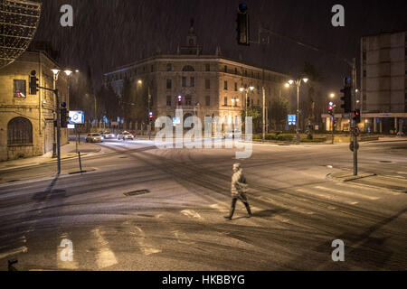 Gerusalemme, Israele. 27 gennaio, 2017. Un pedone passeggiate sulla neve strada coperta di Gerusalemme. Gerusalemme ha visto una nevicata Venerdì notte. Credito: Guo Yu/Xinhua/Alamy Live News Foto Stock