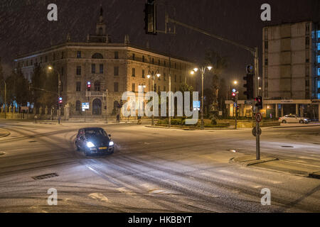 Gerusalemme, Israele. 27 gennaio, 2017. Una macchina corre su una coperta di neve della strada di Gerusalemme. Gerusalemme ha visto una nevicata Venerdì notte. Credito: Guo Yu/Xinhua/Alamy Live News Foto Stock