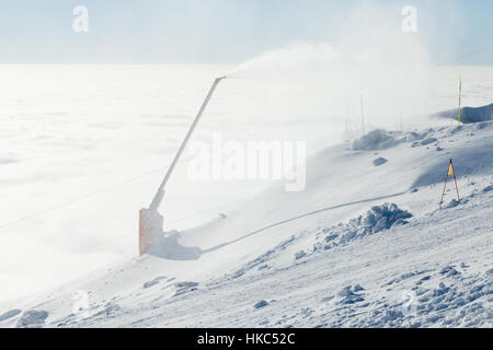 Neve cannoni la produzione di polvere su una pista da sci Foto Stock