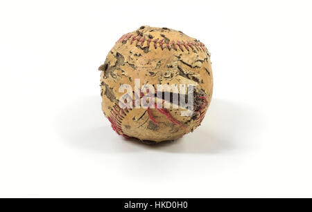 Un vecchio baseball che ha visto giorni migliori. Cuciture strappato, pelle scoloriti strappato e lacerato seduto su un pulito sullo sfondo bianco. Foto Stock