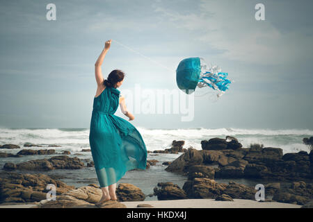 Donna battenti una medusa kite in spiaggia, immagine simbolica, Cape Recife, Port Elizabeth, Sud Africa Foto Stock