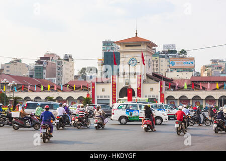 La città di HO CHI MINH, VIETNAM - 2 febbraio 2016: auto e moto rush intorno a Saigon Mercato Centrale conosciuto localmente come Ben Thanh. Foto Stock