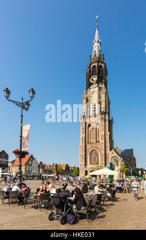 DELFT, Paesi Bassi - 28 Maggio 2016: le persone godono di un caffè sul Delft città vecchia piazza principale di fronte all'alto nuova chiesa (Nieuwe Kerk). Foto Stock