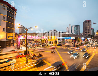 KUALA LUMPUR, Malesia - 13 Marzo 2015: Autovetture e autobus correre attraverso un incrocio di Kuala Lumpur al tramonto in Malesia la città capitale. Foto Stock