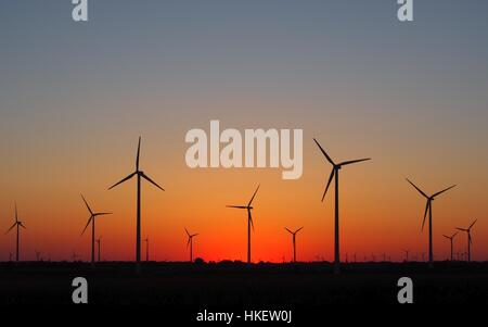 Le turbine eoliche sagome sul cielo rosso tramonto Foto Stock