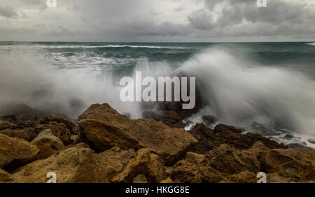 La frantumazione delle onde sulle rocce. Foto Stock