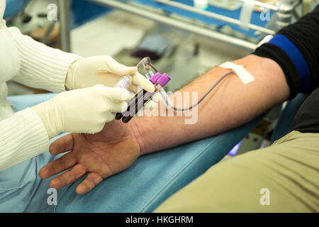 La mano di un donatore di sangue durante il processo di donazione di sangue in un ospedale. Il prelievo di campioni di sangue di prova. Foto Stock