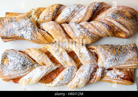 Dolce intrecciato di pasta sfoglia cosparsa con semi di papavero Foto Stock