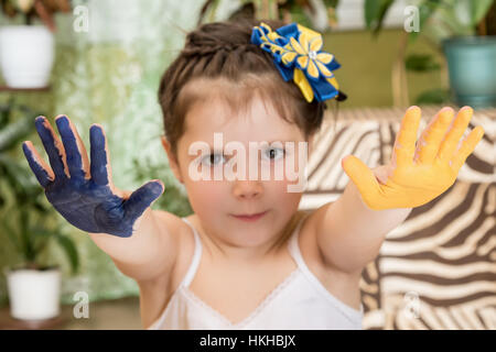 Bambino con le mani tese dipinte Foto Stock