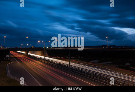Sentieri di luce dalle automobili si muove velocemente nella tarda serata. Concetto di alta velocità Foto Stock