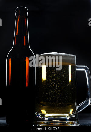 Bottiglia di birra e vetro su sfondo nero Foto Stock