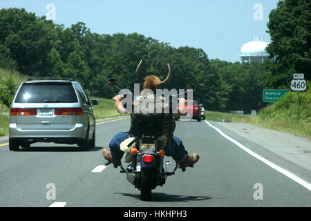 Motociclista sulla strada, che indossa un casco a corno Foto Stock