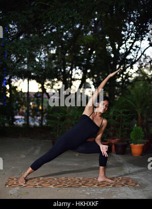 Latino la ragazza facendo mattina yoga in giardino Foto Stock