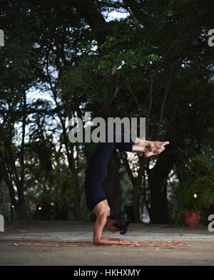 Ragazza facendo yoga nel giardino della sera Foto Stock