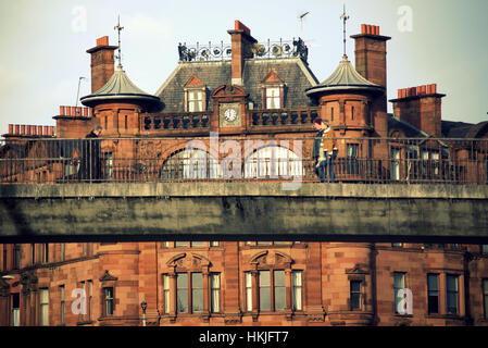 La gente sul ponte pedonale a St George MANSIONS at charing cross e Sauchiehall Street Glasgow Foto Stock