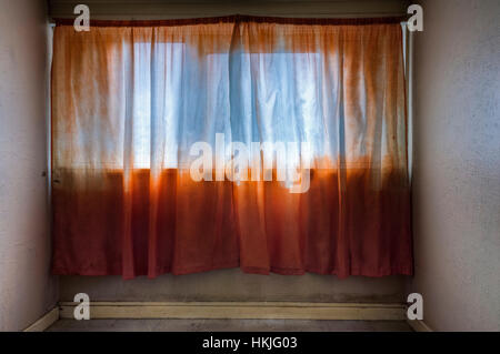 Camera vuota in un alto isolato di appartamenti con orange net curtains. Foto Stock