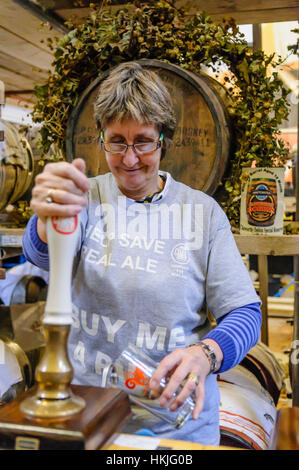 Una donna tira una pinta a una campagna per Real Ale festival. Foto Stock