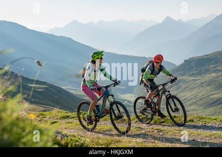 Due mountain biker amici equitazione sulla salita, Zillertal, Tirolo, Austria Foto Stock