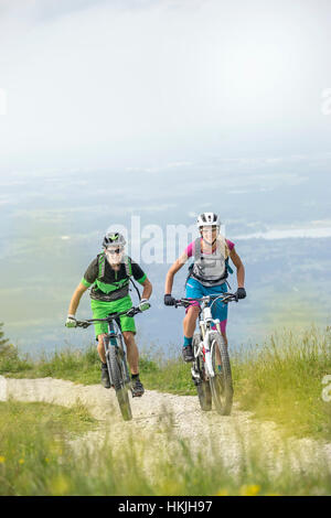 Gli amanti della mountain bike Escursioni in bicicletta in salita in natura, Kampenwand, Baviera, Germania Foto Stock