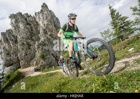 Gli amanti della mountain bike Escursioni in bicicletta in salita in natura, Kampenwand, Baviera, Germania Foto Stock