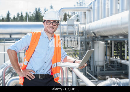 Ritratto di un ingegnere di lavoro sul computer portatile presso stazione elettrica geotermica, Baviera, Germania Foto Stock