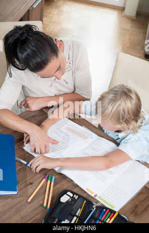 Donna aiutare suo figlio con i suoi compiti, Baviera, Germania Foto Stock
