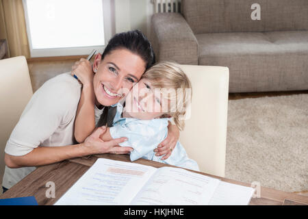 Ritratto di un ragazzo che abbraccia la sua madre mentre studiava,Baviera,Germania Foto Stock