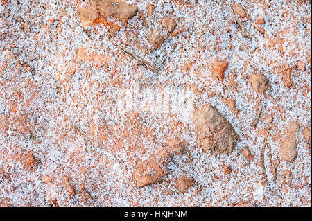 Neve intorno a pietre rosse texture in inverno Foto Stock