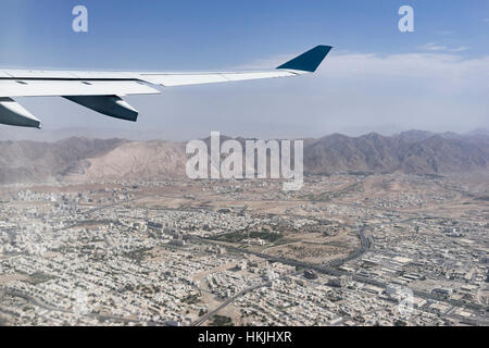 Immagine ritagliata di aeroplano che vola sopra la città, Maskat, Oman Foto Stock