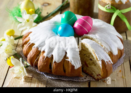 Pasqua tradizionale torta alimentare: l'impasto avvolto in un rotolo con il dado di riempimento e uvetta, con glassa dolce. Festosa tavola di Pasqua. Foto Stock