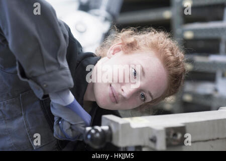 Giovane ingegnere femmina leva di azionamento in un impianto industriale di Freiburg im Breisgau, Baden-Württemberg, Germania Foto Stock