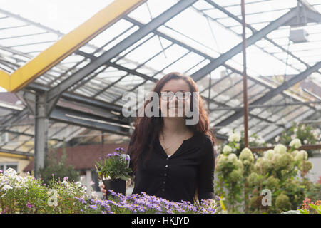 Felice giovane donna in serra,Freiburg im Breisgau,Baden-Württemberg, Germania Foto Stock