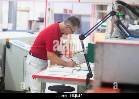 Ingegnere maschio esaminando il circuito stampato nell'industria,Hannover, Bassa Sassonia, Germania Foto Stock