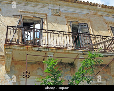 Rovinato balcone su un edificio rimasto abbandonato dopo il terremoto del 1953 nel villaggio di Assos sull'isola greca di Cefalonia in Grecia. Foto Stock