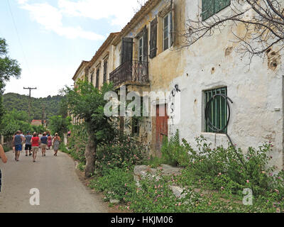 I turisti e gli edifici in rovina abbandonata dopo il terremoto del 1953 nel villaggio di Assos sull'isola greca di Cefalonia in Grecia. Foto Stock