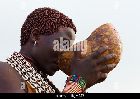 Hamar tribù di persone in abiti tradizionali di bere vino, Hamar Village, Sud Omo, Etiopia Foto Stock