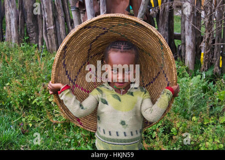 Ragazzo che indossa il coperchio di injera pane piatto contenitore, Addis Abeba, Etiopia Foto Stock