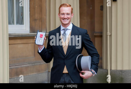 Ponticello lungo Greg Rutherford di ricevere il suo membro dell'Impero Britannico (MBE) medaglia per i servizi di atletica da HM la regina Foto Stock