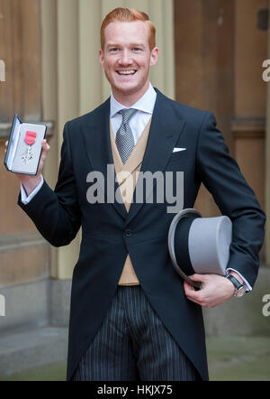 Ponticello lungo Greg Rutherford di ricevere il suo membro dell'Impero Britannico (MBE) medaglia per i servizi di atletica da HM la regina Foto Stock