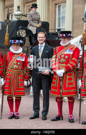 Ponticello lungo Greg Rutherford di ricevere il suo membro dell'Impero Britannico (MBE) medaglia per i servizi di atletica da HM la regina Foto Stock