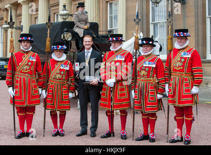 Ponticello lungo Greg Rutherford di ricevere il suo membro dell'Impero Britannico (MBE) medaglia per i servizi di atletica da HM la regina Foto Stock