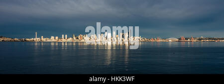 Come il sole tramonta edifici della skyline di Seattle sono riflesse nella Baia di Elliott. Foto Stock