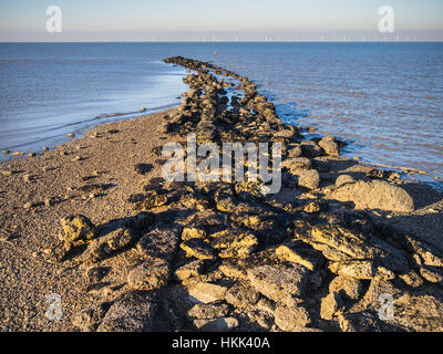 Hampton pier mare difese, vicino a Herne Bay e a Whitstable, Kent, Regno Unito. La Kentish Flats wind farm può essere visto all'orizzonte. Foto Stock